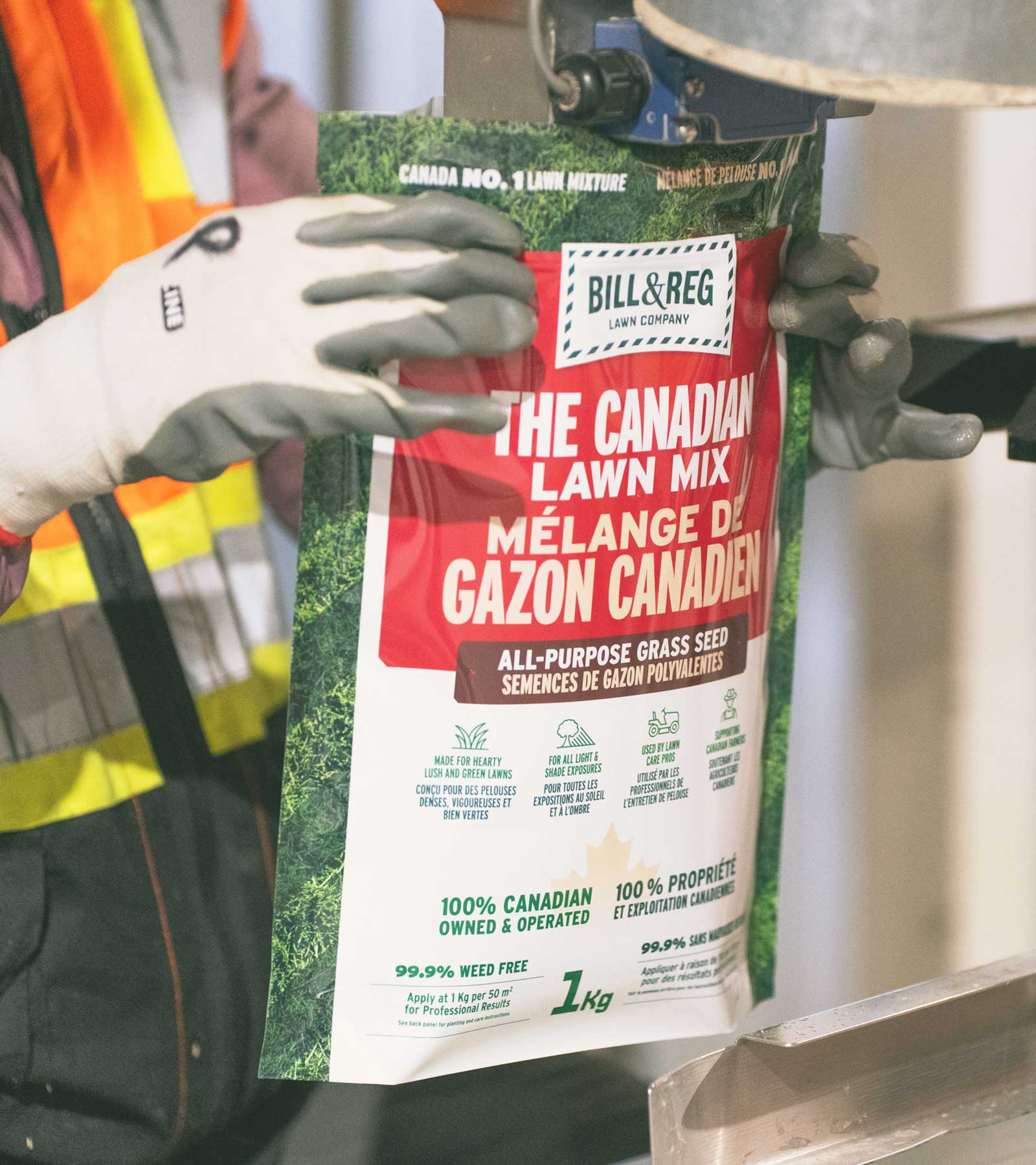 Person holding a package of Bill & Beg Canadian Lawn Mix with safety gear in the background